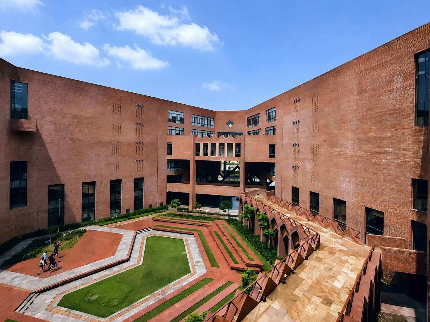 A large modern university campus building set in green grounds in India